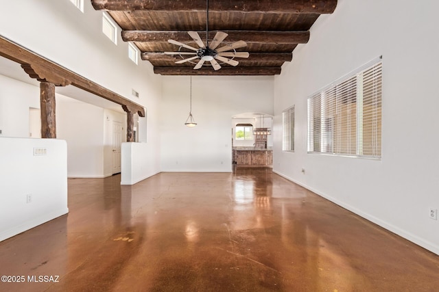 13940 E Hay Bale Trl, Vail, AZ 85641 - unfurnished living room with concrete flooring, beam ceiling, wooden ceiling, ceiling fan, and arched walkways
