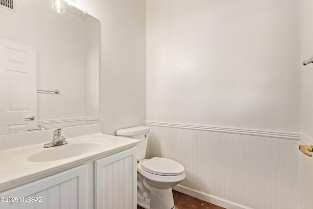 13940 E Hay Bale Trl, Vail, AZ 85641 - half bathroom featuring toilet, vanity, and a wainscoted wall
