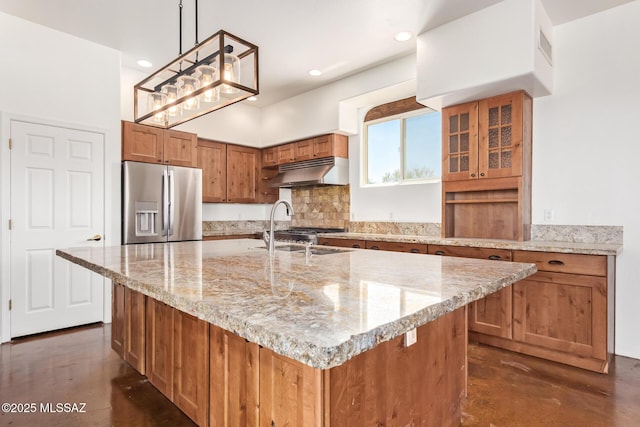 13940 E Hay Bale Trl, Vail, AZ 85641 - kitchen with stainless steel fridge with ice dispenser, under cabinet range hood, brown cabinets, a sink, and light stone countertops