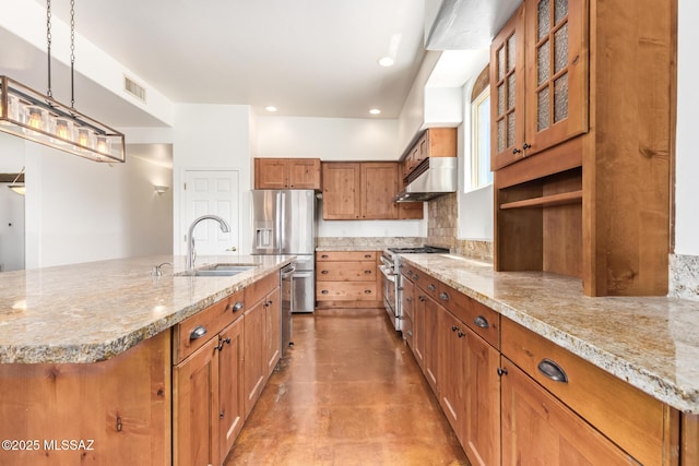 13940 E Hay Bale Trl, Vail, AZ 85641 - kitchen with appliances with stainless steel finishes, under cabinet range hood, brown cabinets, a sink, and light stone countertops