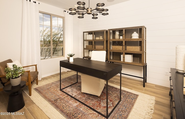 home office featuring a chandelier and light wood-style flooring