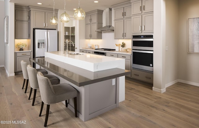 kitchen featuring gray cabinetry, stainless steel appliances, a sink, baseboards, and recessed lighting