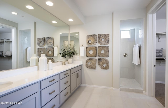full bathroom with walk in shower, baseboards, double vanity, and recessed lighting