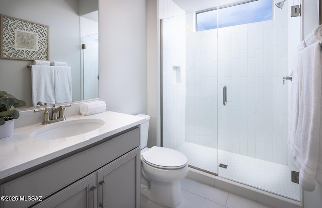 bathroom featuring a shower stall, toilet, vanity, and tile patterned flooring