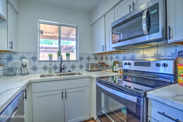 957 N Camino Las Solanas, Tucson, AZ 85710 - kitchen with appliances with stainless steel finishes, a sink, white cabinets, and light stone countertops