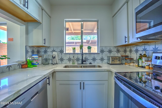 957 N Camino Las Solanas, Tucson, AZ 85710 - kitchen featuring stainless steel appliances, a sink, light stone countertops, and white cabinetry