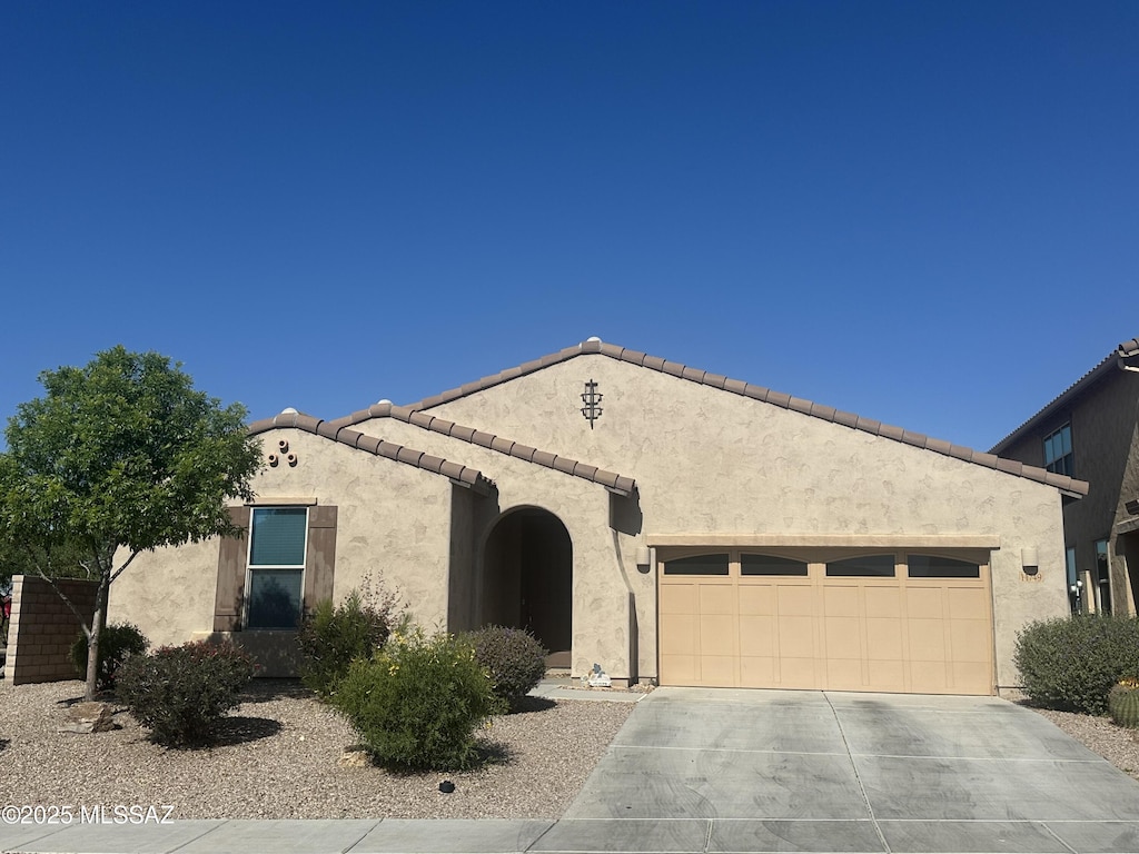 11749 N Key Lime Pl, Oro Valley, AZ 85742 - mediterranean / spanish-style home with an attached garage, concrete driveway, stucco siding, and a tile roof