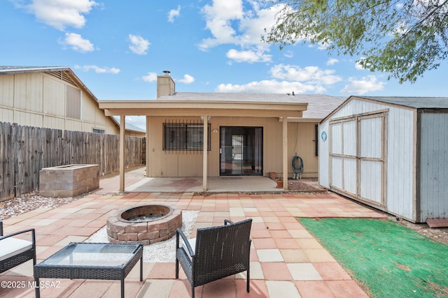 4765 S Windrose Dr, Tucson, AZ 85730 - back of house with an outdoor fire pit, a patio area, a shed, a chimney, and fence