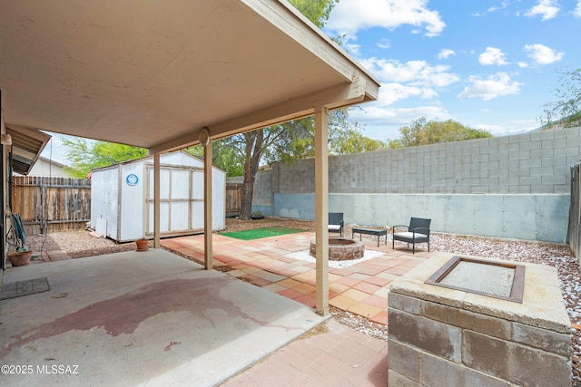 4765 S Windrose Dr, Tucson, AZ 85730 - view of patio / terrace featuring an outdoor fire pit, a storage shed, an outbuilding, and a fenced backyard