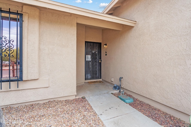 4765 S Windrose Dr, Tucson, AZ 85730 - doorway to property with stucco siding