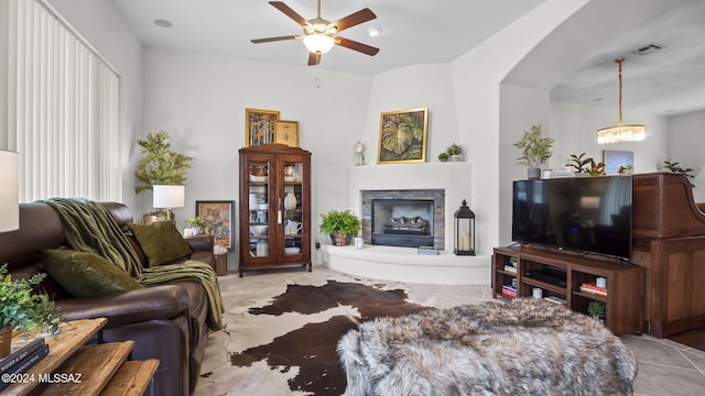 15083 S Placita Rancho Verano, Sahuarita, AZ 85629 - living area with a chandelier, a fireplace with raised hearth, ceiling fan, arched walkways, and tile patterned flooring