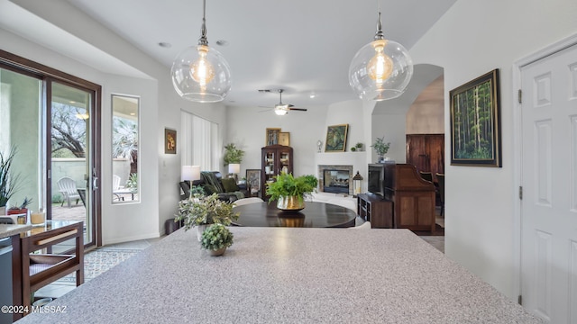 15083 S Placita Rancho Verano, Sahuarita, AZ 85629 - dining room featuring a ceiling fan, a glass covered fireplace, and arched walkways