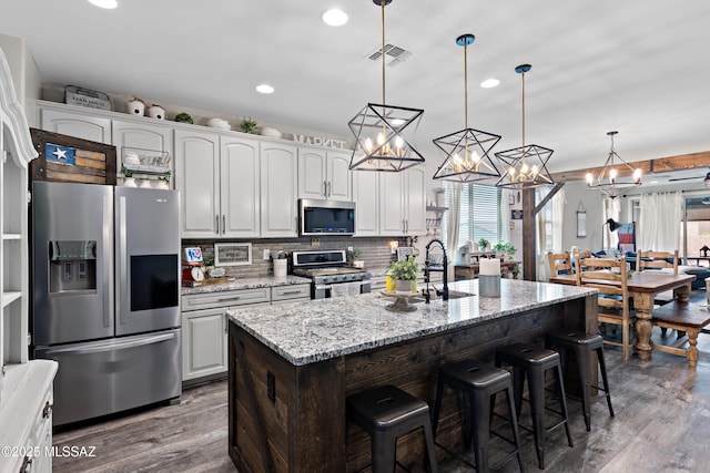 14233 E Hub Dr, Vail, AZ 85641 - kitchen featuring appliances with stainless steel finishes, a sink, dark wood-style floors, a kitchen breakfast bar, and recessed lighting