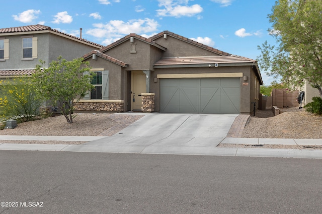14233 E Hub Dr, Vail, AZ 85641 - view of front of house with an attached garage, driveway, stucco siding, stone siding, and a tile roof