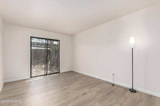empty room with light wood finished floors and baseboards