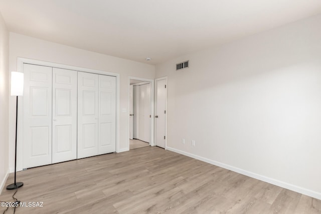 unfurnished bedroom with light wood-style flooring and baseboards