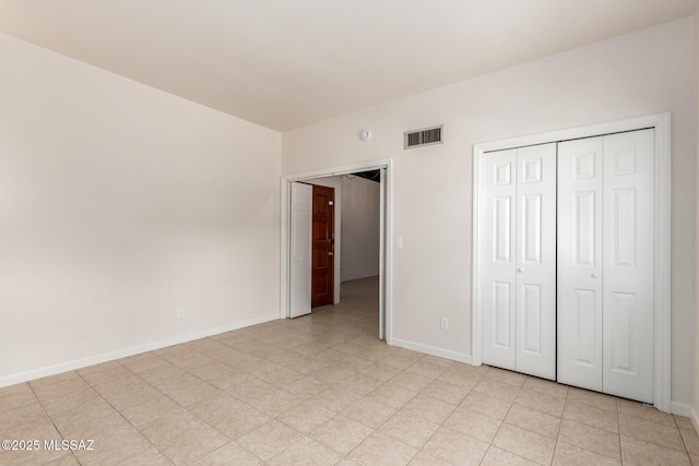 unfurnished bedroom with baseboards and a closet