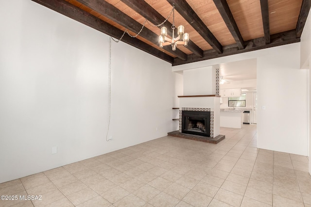 unfurnished living room featuring beam ceiling, a tiled fireplace, a chandelier, light tile patterned floors, and a ceiling fan
