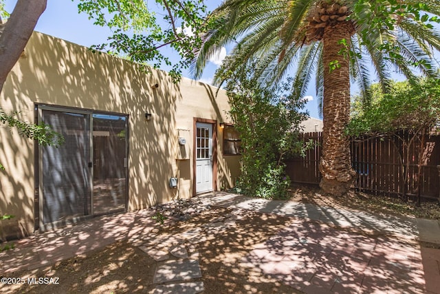 back of house featuring a patio, stucco siding, and fence