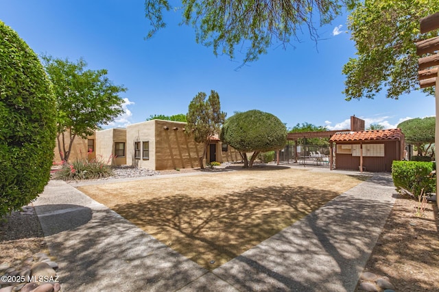 view of front of property with a gate, fence, stucco siding, and a chimney