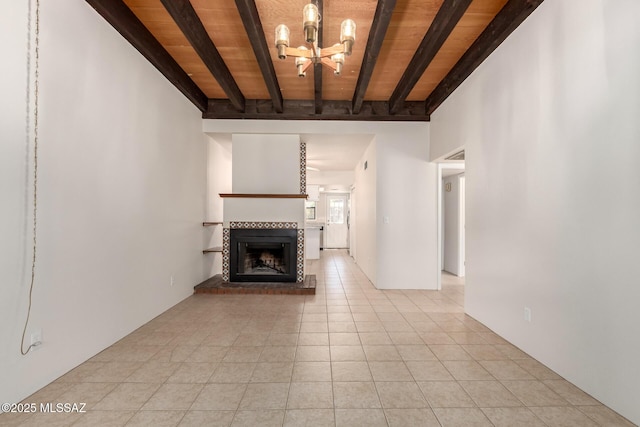 unfurnished living room featuring beam ceiling, wood ceiling, a chandelier, a tile fireplace, and light tile patterned floors
