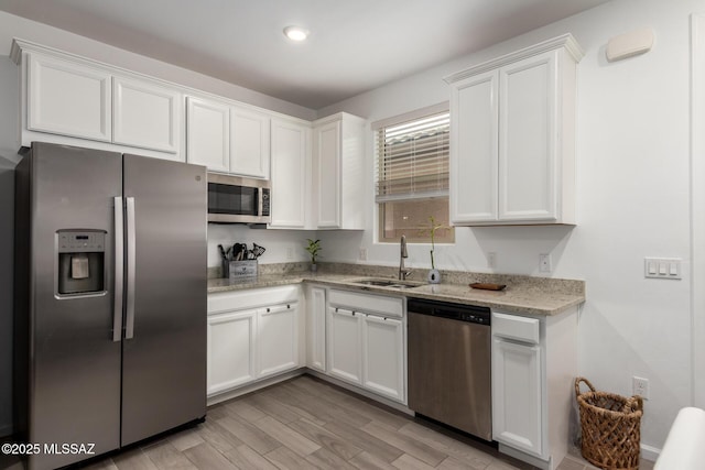 7988 S Bonanza Park Dr, Tucson, AZ 85747 - kitchen with stainless steel appliances, a sink, white cabinetry, light stone counters, and recessed lighting