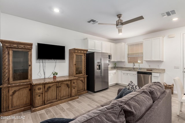 7988 S Bonanza Park Dr, Tucson, AZ 85747 - kitchen featuring appliances with stainless steel finishes, a sink, open floor plan, ceiling fan, and white cabinets