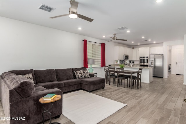 7988 S Bonanza Park Dr, Tucson, AZ 85747 - living room featuring a ceiling fan, light wood finished floors, and recessed lighting