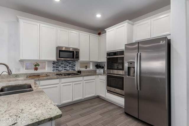 7988 S Bonanza Park Dr, Tucson, AZ 85747 - kitchen featuring appliances with stainless steel finishes, a sink, white cabinetry, light stone counters, and recessed lighting