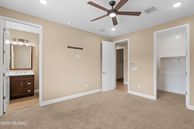 60922 E Arbor Basin Rd, Oracle, AZ 85623 - unfurnished bedroom featuring baseboards, a spacious closet, light carpet, recessed lighting, and connected bathroom