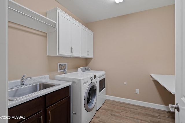 60922 E Arbor Basin Rd, Oracle, AZ 85623 - washroom featuring washing machine and dryer, cabinet space, light wood finished floors, and baseboards