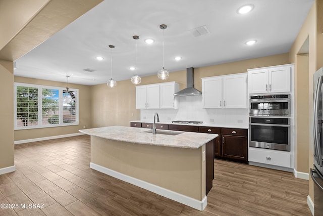 60922 E Arbor Basin Rd, Oracle, AZ 85623 - kitchen featuring wall chimney exhaust hood, a sink, appliances with stainless steel finishes, baseboards, and white cabinetry