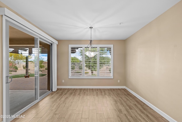 60922 E Arbor Basin Rd, Oracle, AZ 85623 - unfurnished dining area featuring light wood finished floors, baseboards, and a chandelier
