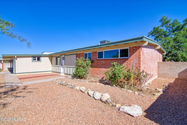 view of front of property featuring brick siding and fence