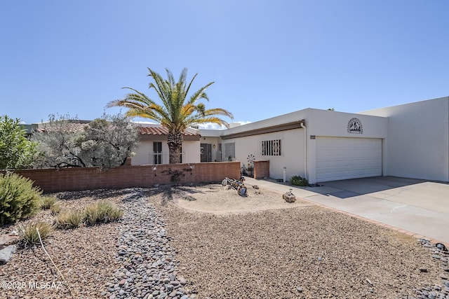 723 S Los Zafiros, Green Valley, AZ 85614 - view of front of home with an attached garage, driveway, stucco siding, and fence