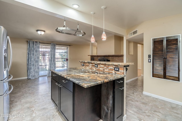 2 S Antietam Pl, Tucson, AZ 85710 - kitchen with stainless steel refrigerator with ice dispenser, baseboards, light stone counters, pendant lighting, and a center island