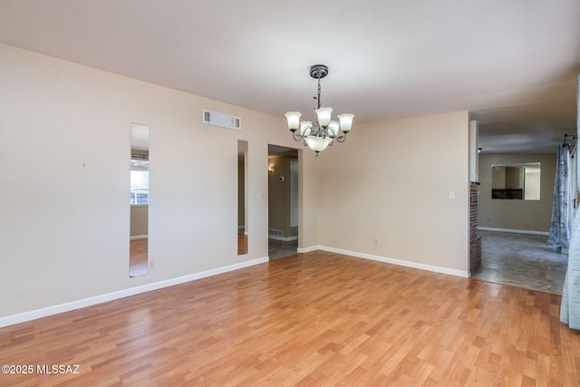 2 S Antietam Pl, Tucson, AZ 85710 - unfurnished room with a chandelier, light wood-style floors, and baseboards