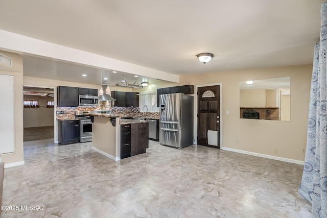 2 S Antietam Pl, Tucson, AZ 85710 - kitchen with appliances with stainless steel finishes, a center island, wall chimney exhaust hood, a kitchen bar, and decorative backsplash