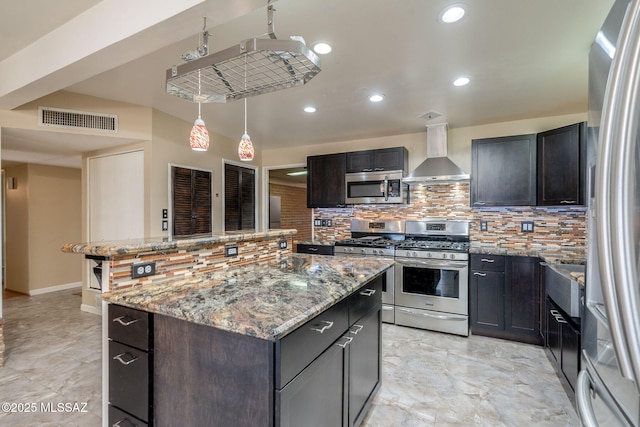 2 S Antietam Pl, Tucson, AZ 85710 - kitchen with stainless steel appliances, wall chimney range hood, decorative backsplash, light stone countertops, and a kitchen island