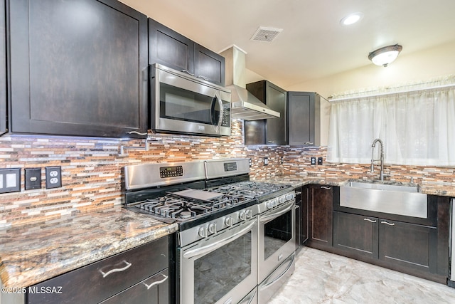 2 S Antietam Pl, Tucson, AZ 85710 - kitchen featuring stainless steel appliances, wall chimney range hood, a sink, stone counters, and decorative backsplash