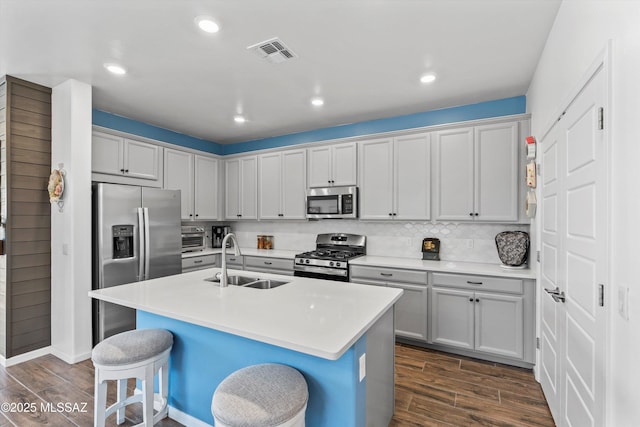 7138 W Ferntree Ln, Tucson, AZ 85757 - kitchen with stainless steel appliances, a sink, dark wood finished floors, a kitchen breakfast bar, and recessed lighting