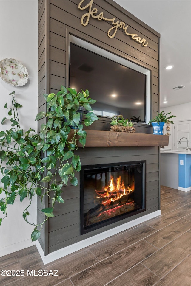 7138 W Ferntree Ln, Tucson, AZ 85757 - detailed view of a glass covered fireplace, wood finished floors, and a sink