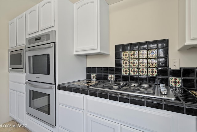 11300 N Scioto Ave, Oro Valley, AZ 85737 - kitchen featuring stainless steel appliances, tile counters, and white cabinets