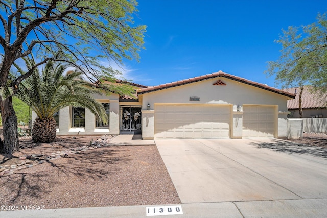 11300 N Scioto Ave, Oro Valley, AZ 85737 - mediterranean / spanish-style home with stucco siding, a tiled roof, driveway, and a garage