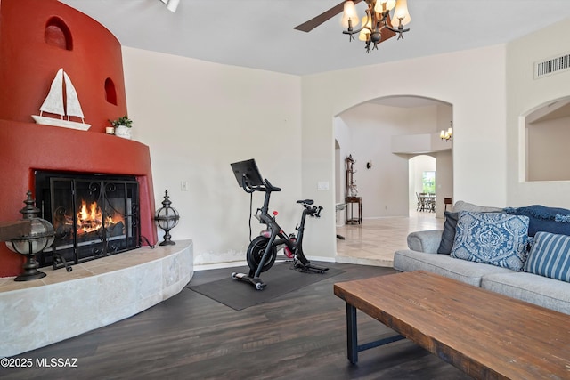 11300 N Scioto Ave, Oro Valley, AZ 85737 - exercise room featuring a chandelier, wood finished floors, arched walkways, and a tiled fireplace