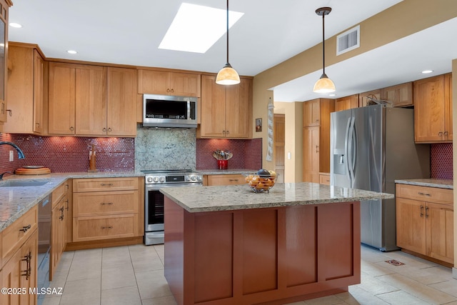 kitchen with stainless steel appliances, a sink, a skylight, decorative backsplash, and a center island
