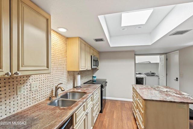 7624 E Helen St, Tucson, AZ 85715 - kitchen featuring black electric range oven, stainless steel microwave, a sink, washing machine and clothes dryer, and a raised ceiling