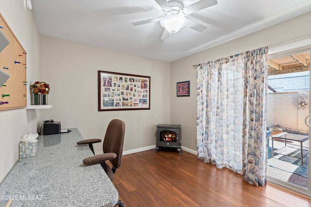 7624 E Helen St, Tucson, AZ 85715 - office area featuring wood finished floors, a wood stove, a ceiling fan, and baseboards