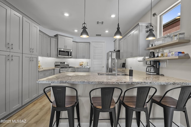 2125 Embarcadero Way, Tubac, AZ 85646 - kitchen with appliances with stainless steel finishes, gray cabinetry, a peninsula, decorative backsplash, and recessed lighting