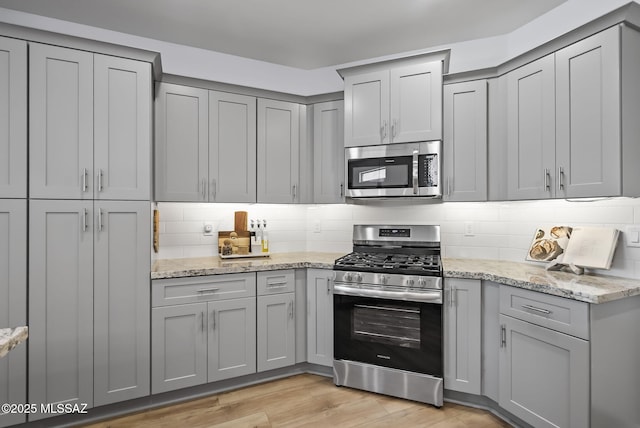 2125 Embarcadero Way, Tubac, AZ 85646 - kitchen with appliances with stainless steel finishes, gray cabinetry, and tasteful backsplash